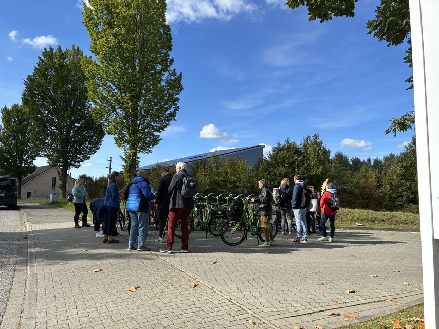 Eine Gruppe Personen neben Fahrrädern stehend