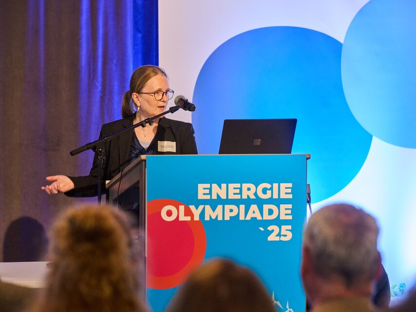 Eine Person hält eine Rede. Auf dem Rednerpult steht Energieolympiade 25.