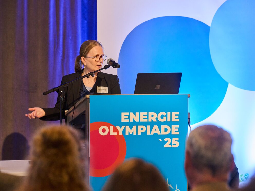 Eine Person hält eine Rede. Auf dem Rednerpult steht Energieolympiade 25.